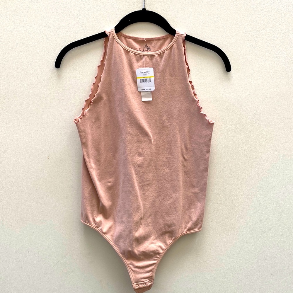Free People NWT light pink bodysuit. Snap closure. Scallop stitching around arms